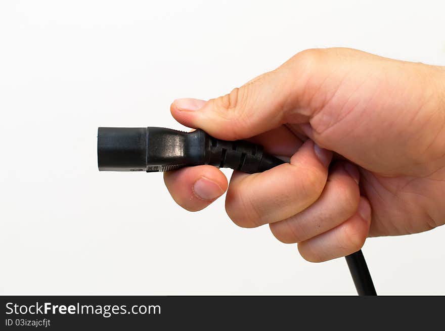 Power supply electrical cord held in a man&#x27;s hand. Power supply electrical cord held in a man&#x27;s hand