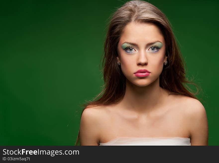 Portrait of a pretty girl on the green background