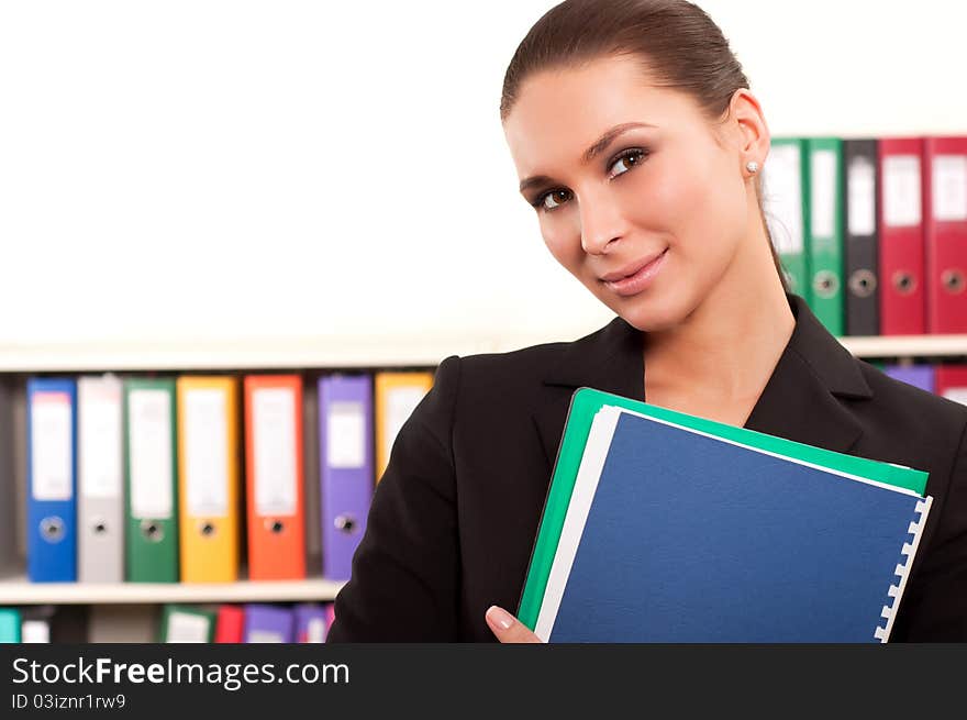 Young business woman in front of shelves with folders