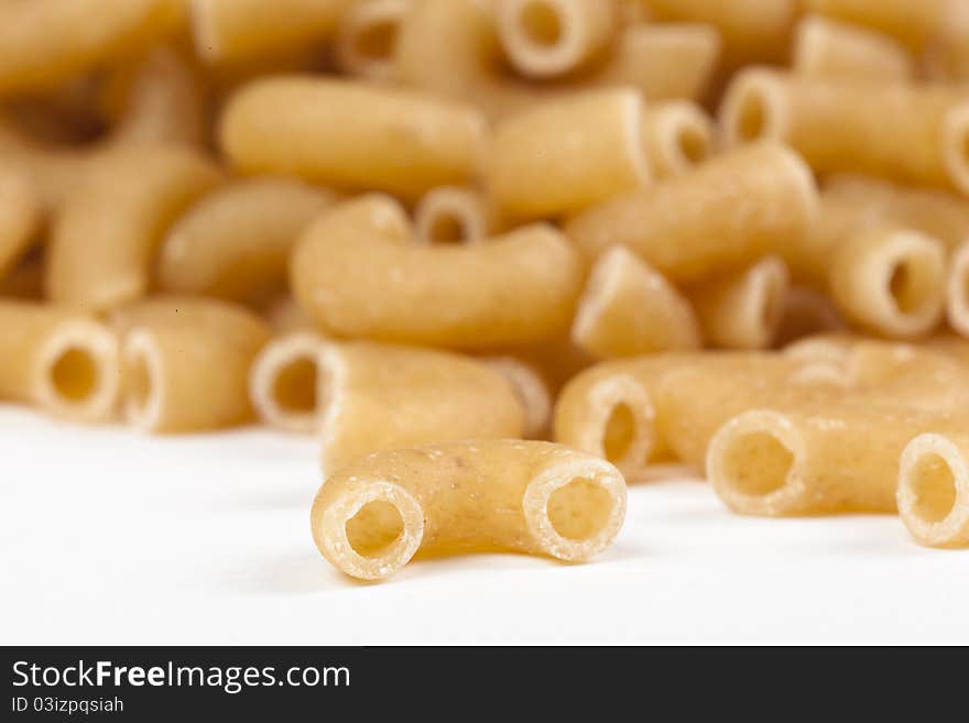 Dry macaroni pasta on a white back ground