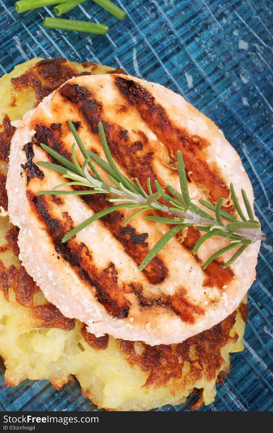 Grilled salmon and roesti with chives and rosemary over a glass dish