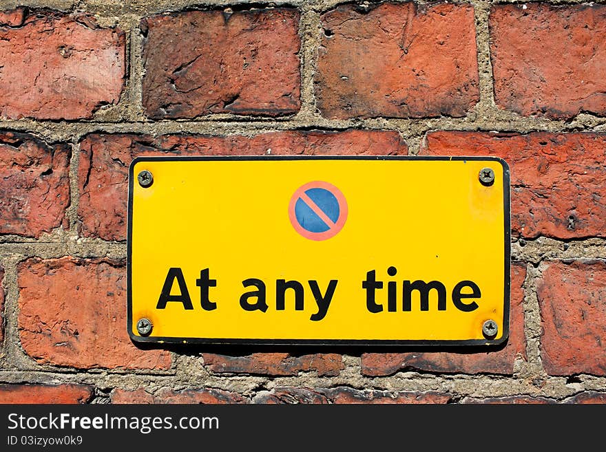 No parking at any time sign on brick wall