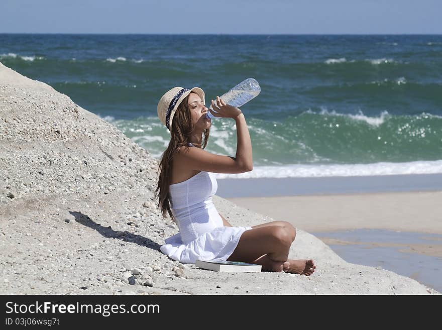 Woman drinking water in the beach