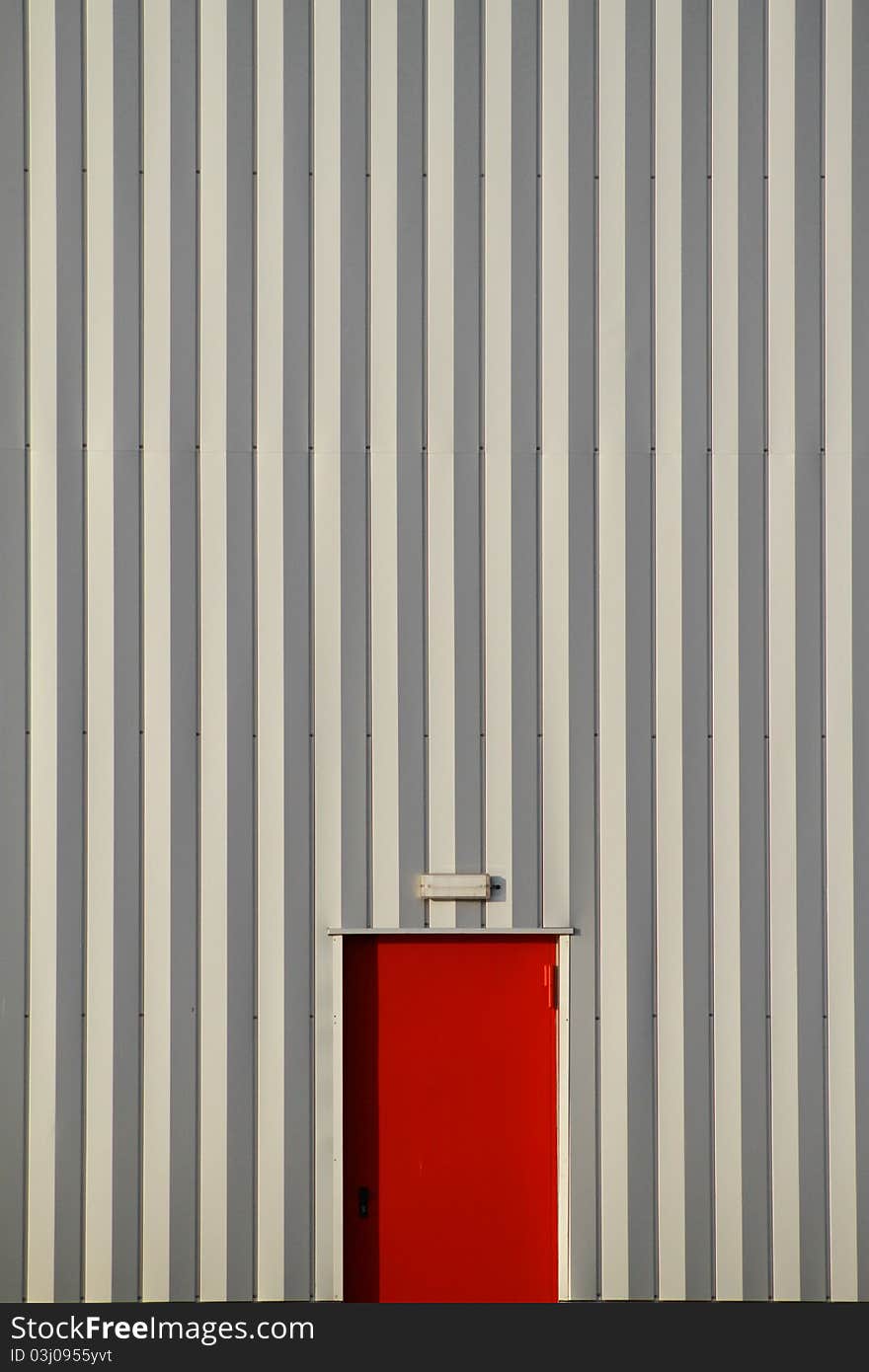 Red door in a wall with with stripes