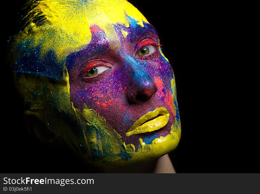 Portrait of an artistic woman painted with colors, over black background. Portrait of an artistic woman painted with colors, over black background.