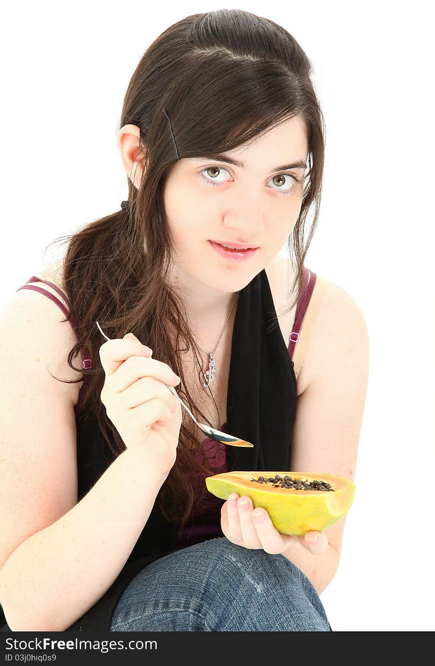 Attractive young woman eating a papaya fruit over white background. Attractive young woman eating a papaya fruit over white background.