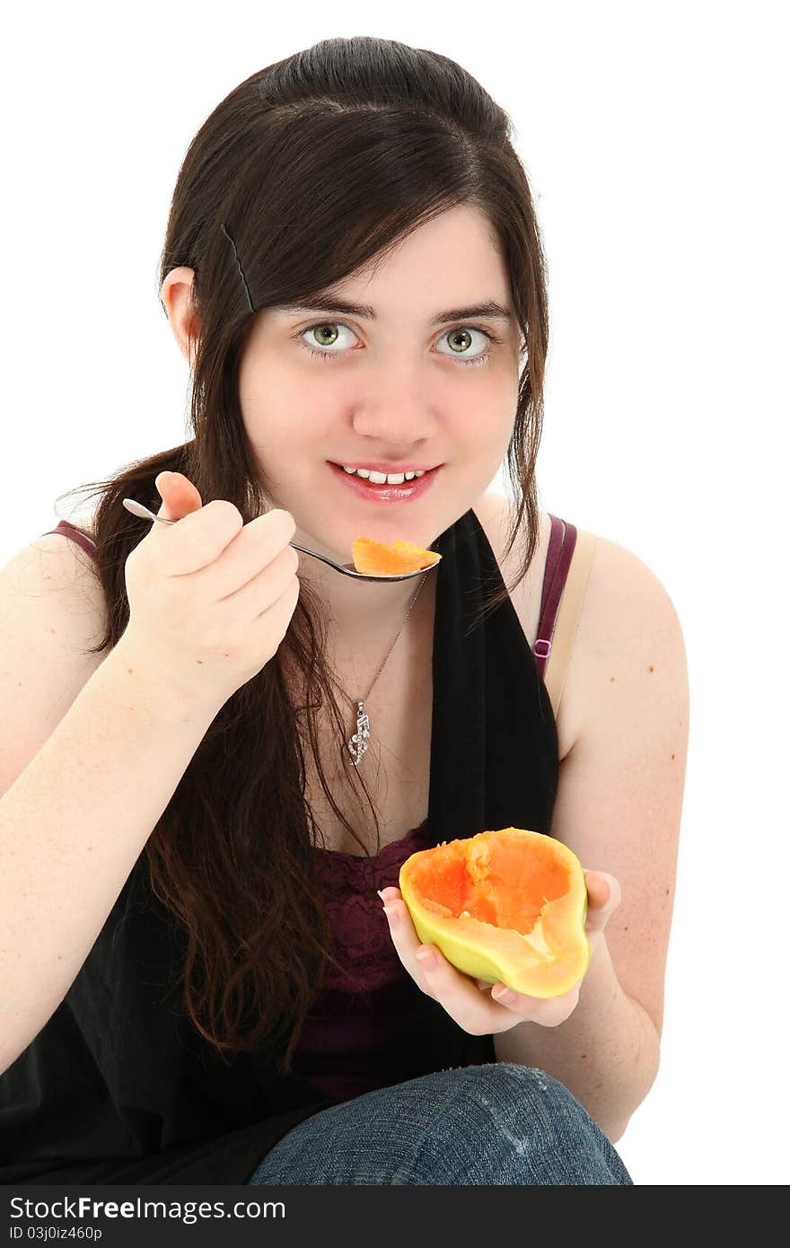 Attractive young woman eating a papaya fruit over white background. Attractive young woman eating a papaya fruit over white background.