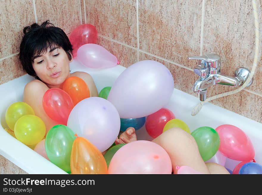 Woman playing with balloons in his bathtub. Woman playing with balloons in his bathtub