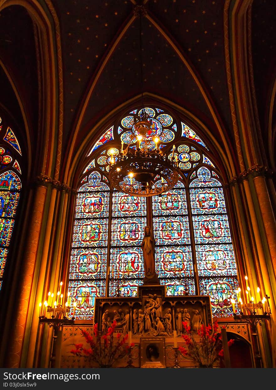 Candle and stained window in Notre Dame , Paris