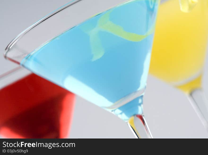 Colorful Tropical Martini style drinks with fruit & garnish closeup