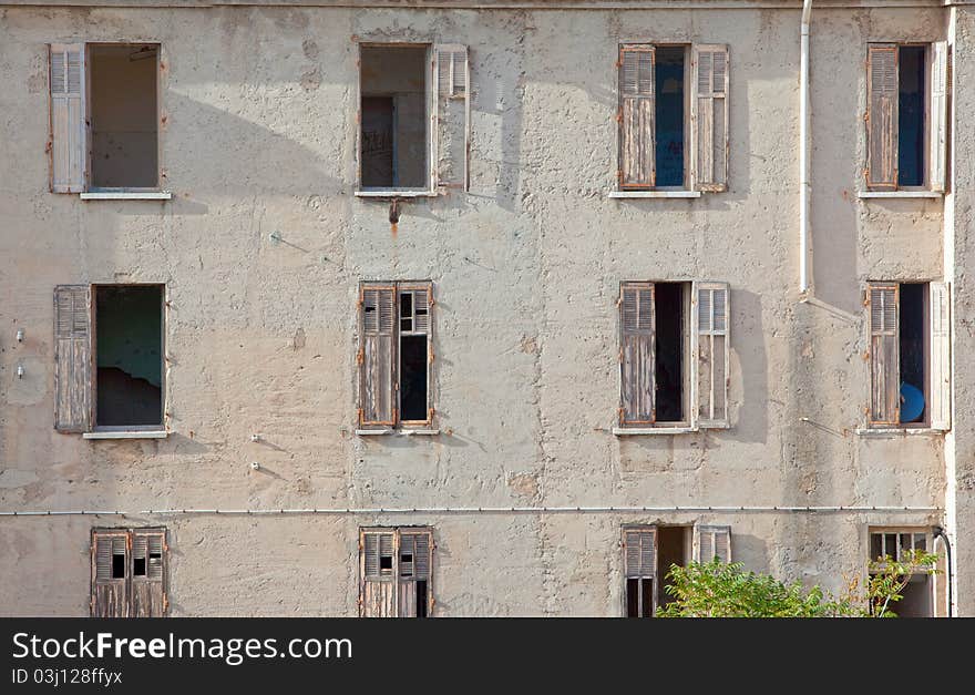 Facade of an old ruined house with broken windows
