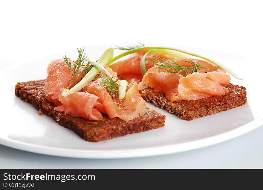 Fresh salmon sandwiches on a white plate