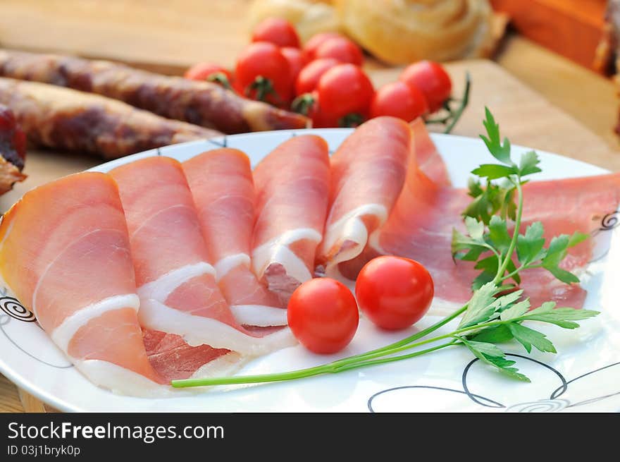 Delicious Italian food, ham and cherry tomato with sausage and parsley. Delicious Italian food, ham and cherry tomato with sausage and parsley