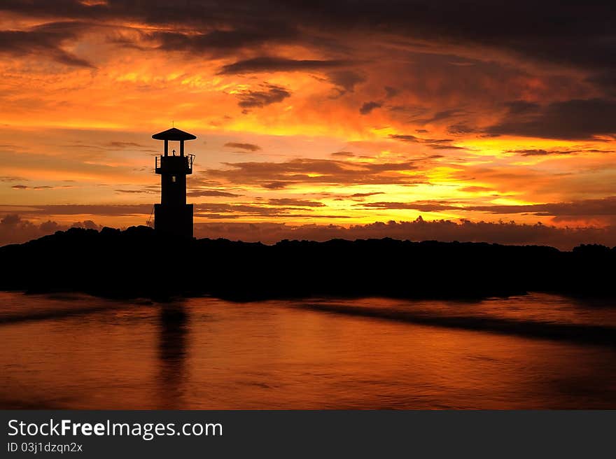 A lighthouse in the sunset sky