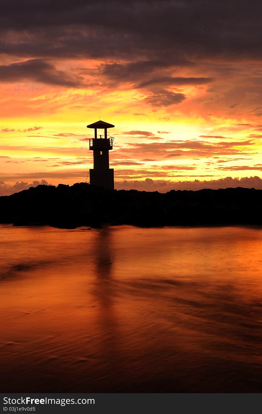 A Lighthouse In The Sunset Sky