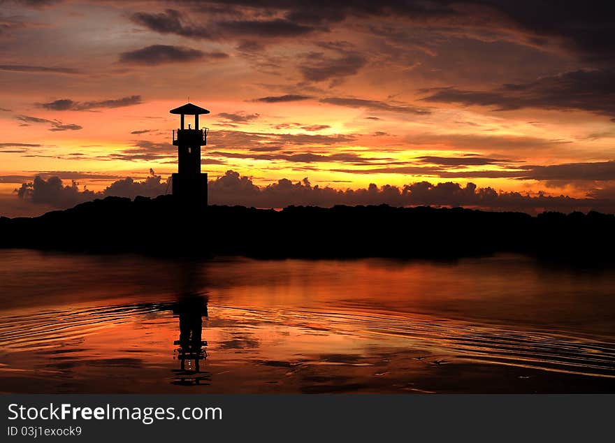 A lighthouse in the sunset sky