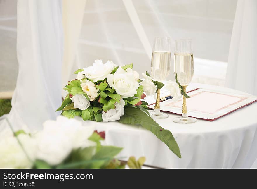 Wineglass,flowers and register book on the table. Wineglass,flowers and register book on the table