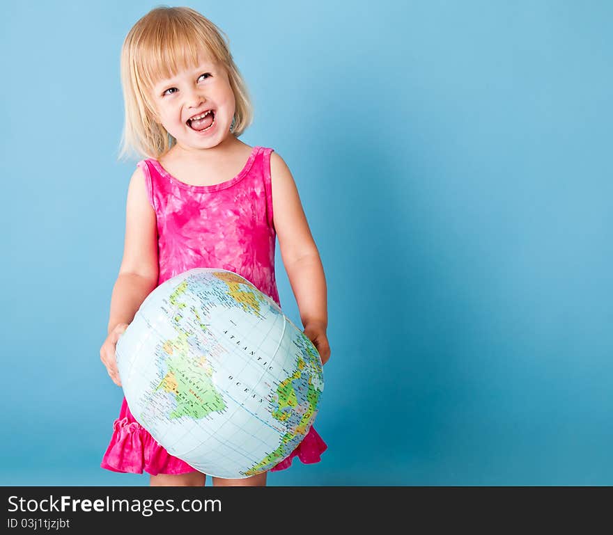 A little girl with a globe on a blue background