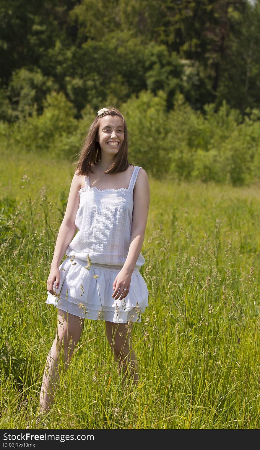 Young smiling girl walking in a meadow