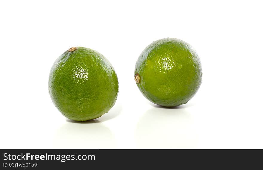 Macro image of two green healthy sour limes isolated over white background