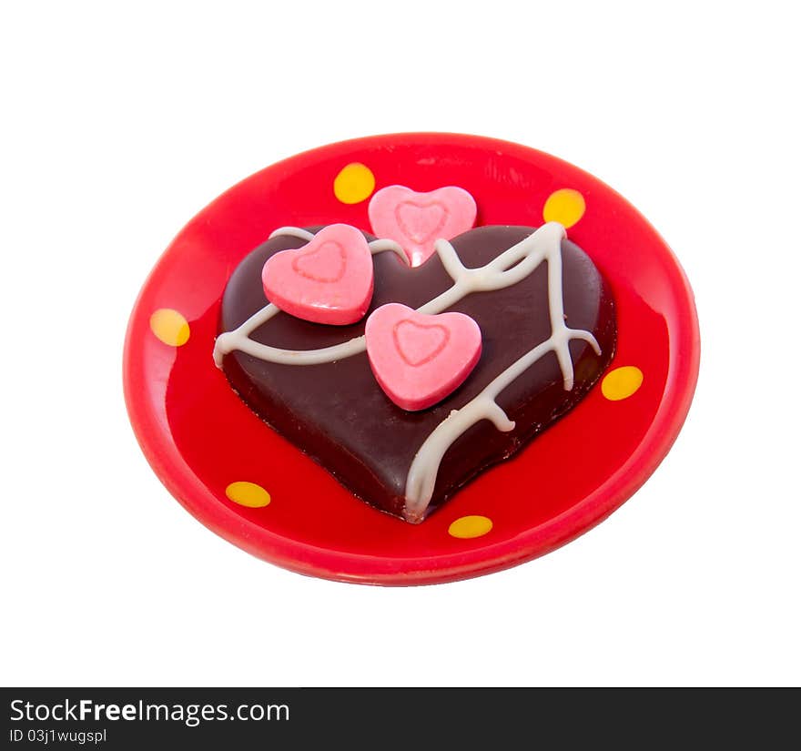 A lovely chocolate heart decorated white pink hearted candy on a ceramic little saucer isolated over white