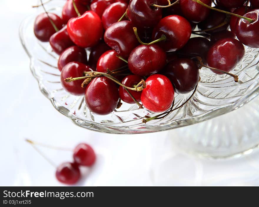 Sweet cherry in glass-ware on white background