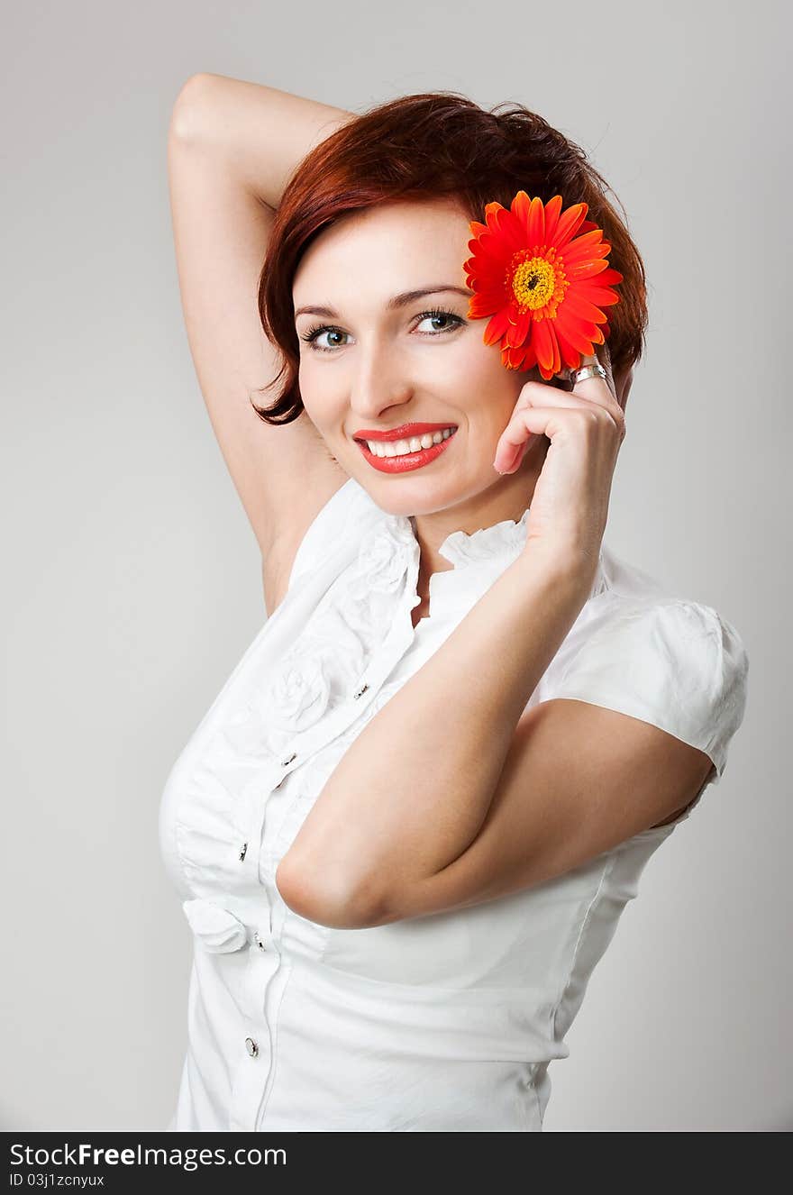 Beautiful woman with flower gerbera in her hands against white background. Beautiful woman with flower gerbera in her hands against white background