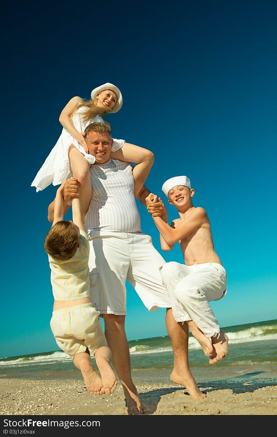 Father holding family on beach while on vacation. Father holding family on beach while on vacation