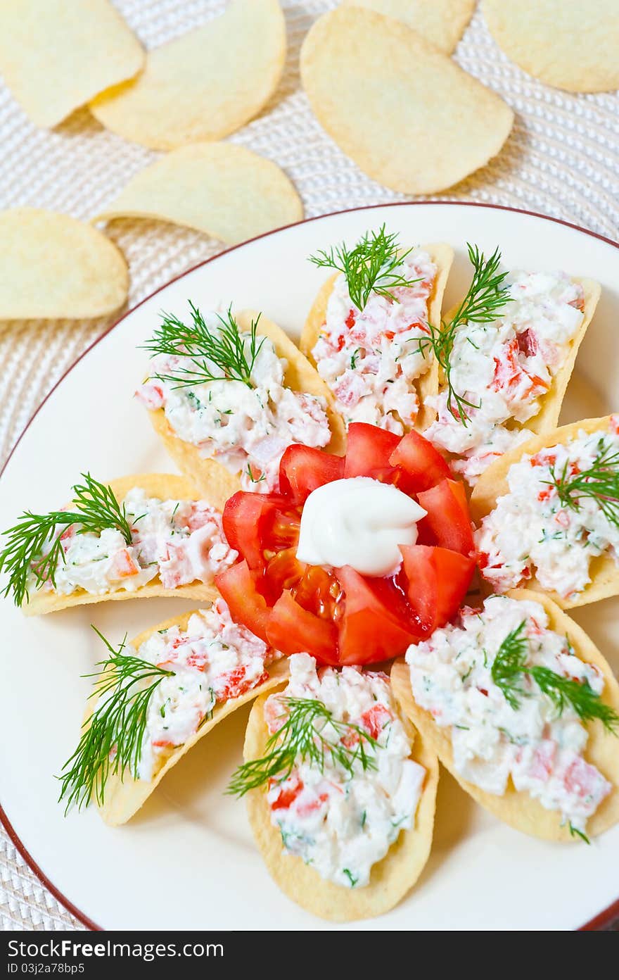 Appetizer on chips with crab meat, Feta cheese and tomato
