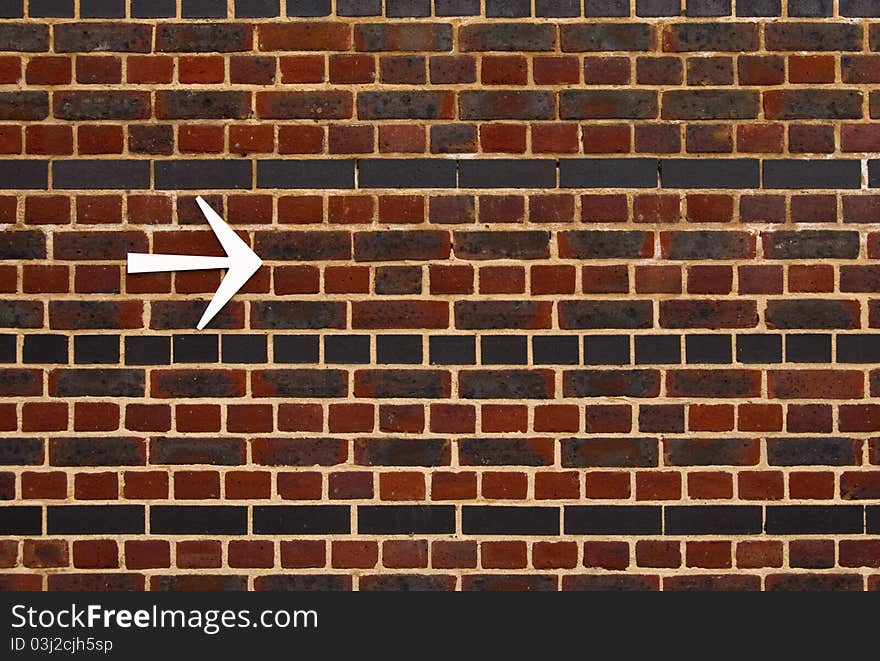 An arrow on a brick wall