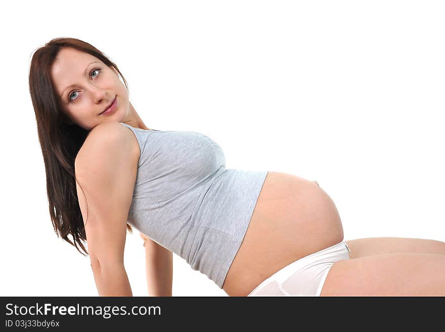 Pregnant woman sitting in living room smiling