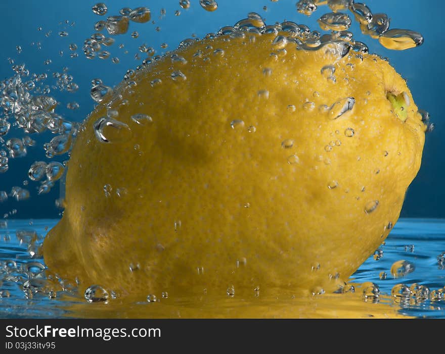 Lemon splash in water isolated on blue. Lemon splash in water isolated on blue