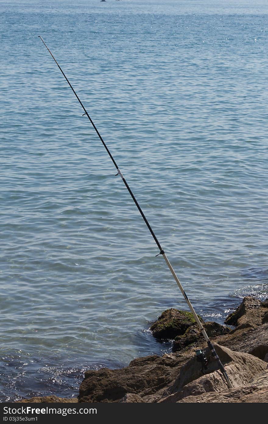 Fishing rod in the rocks on the beach