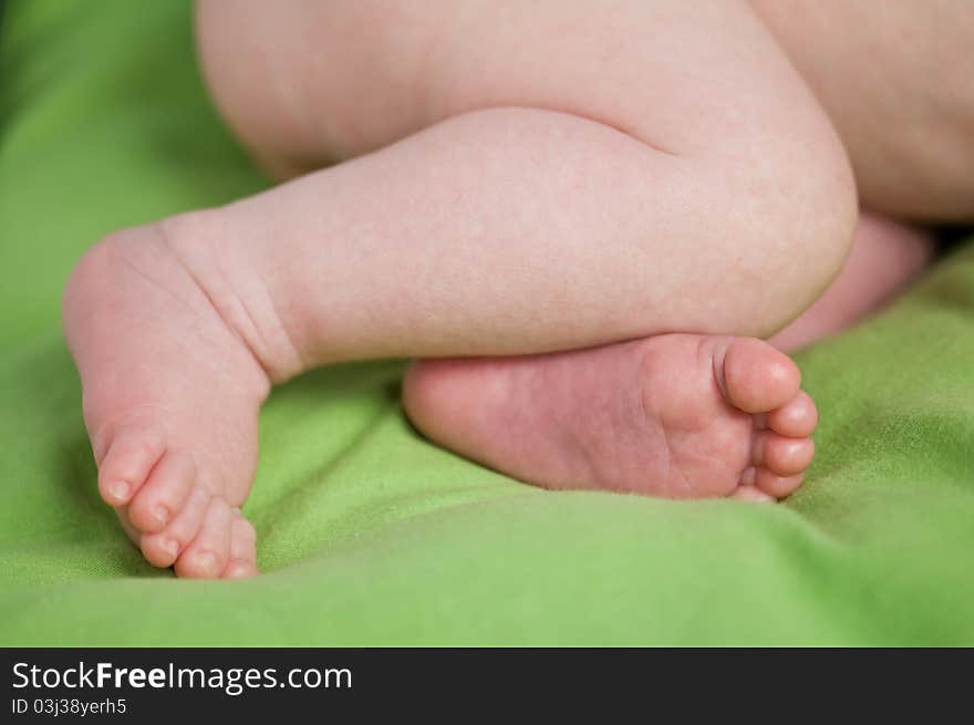 Newborn legs on green sheet