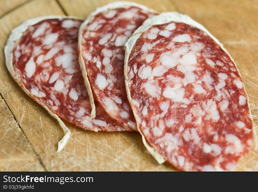 Salami pieces on wood table