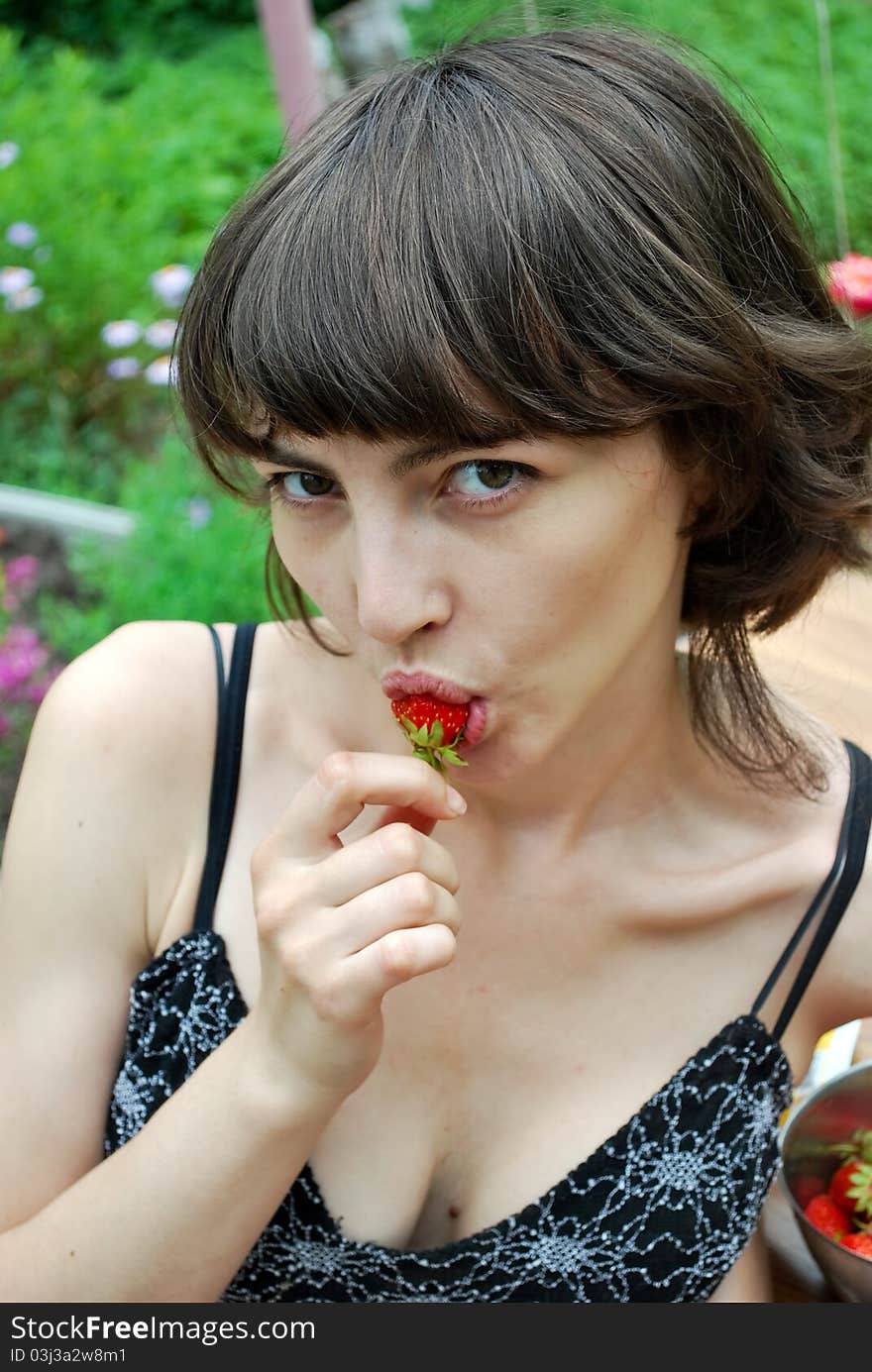 Portrait of woman eating strawberries.