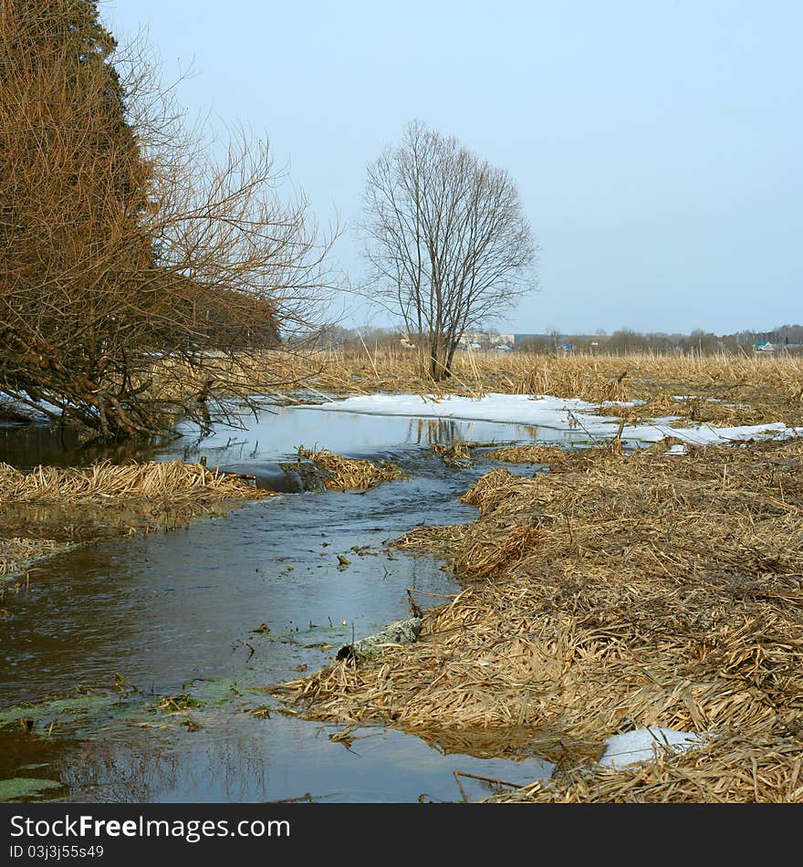 Stream of thawed snow water in the early spring. Panorama from two horizontal shots. Stream of thawed snow water in the early spring. Panorama from two horizontal shots