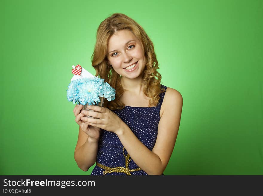 Close-up of an attractive young woman holding a gift bouquet of blue chrysanthemums. In flowers of a romantic note. Close-up of an attractive young woman holding a gift bouquet of blue chrysanthemums. In flowers of a romantic note