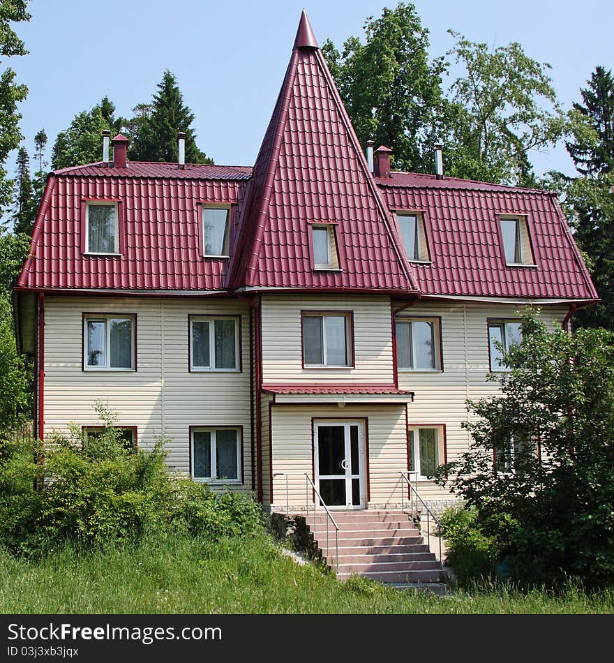 The three-storyed house with a tile roof costs in wood. The three-storyed house with a tile roof costs in wood