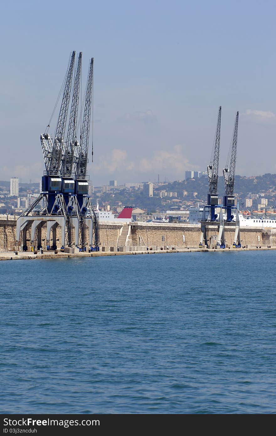 Five cranes on the dock of a harbor. Five cranes on the dock of a harbor