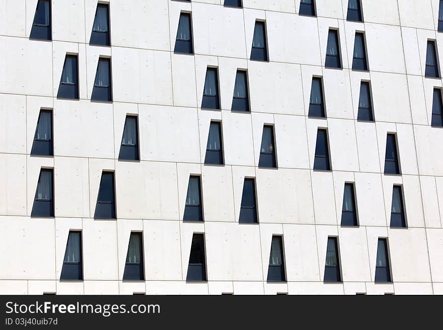 White facade of a modern building with randomly placed windows