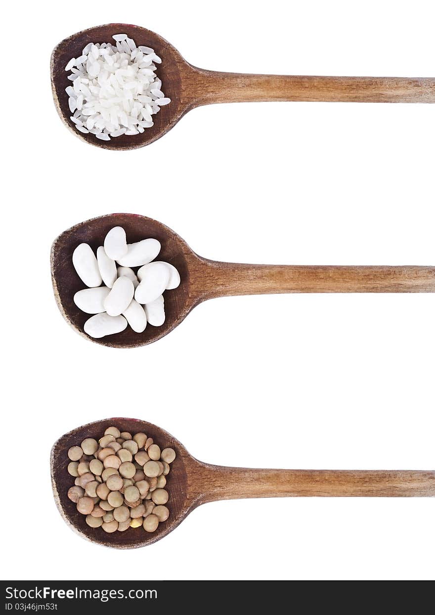 Wood spoons with beans, lentils and rice isolated