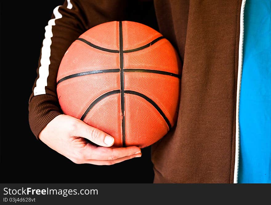 Man holding a basketball on a black background. Man holding a basketball on a black background