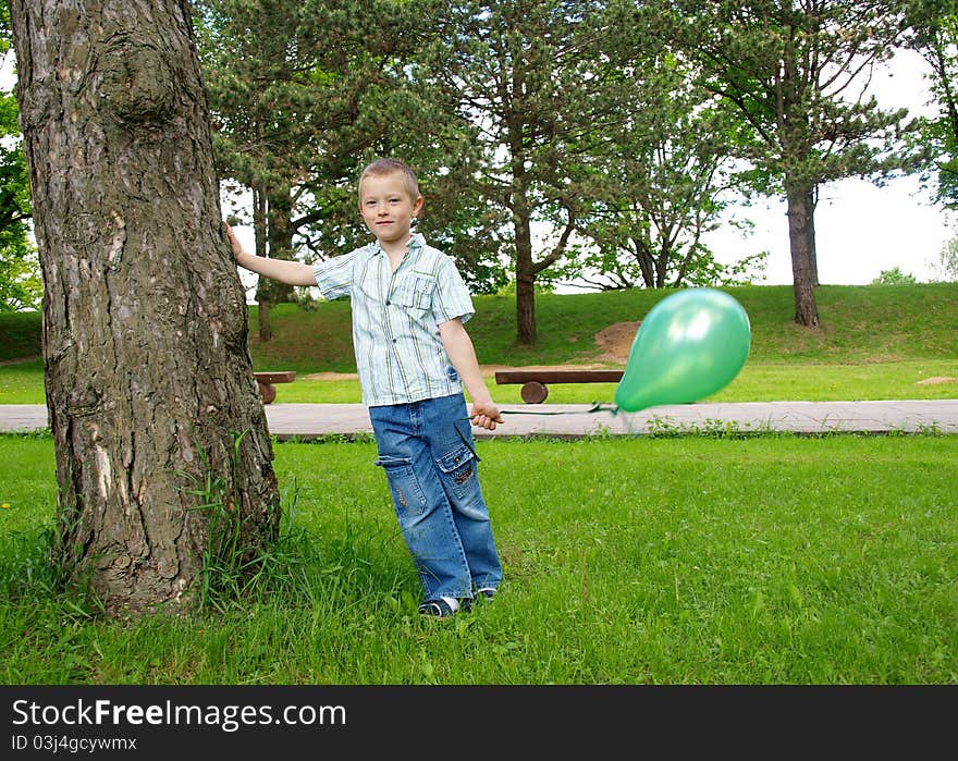 Child standing on the grass and holding a balloon