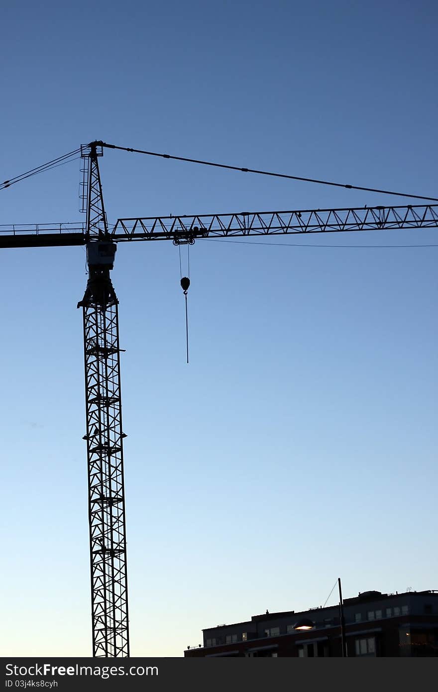 Silhouette of a crane at an apartment bulding site