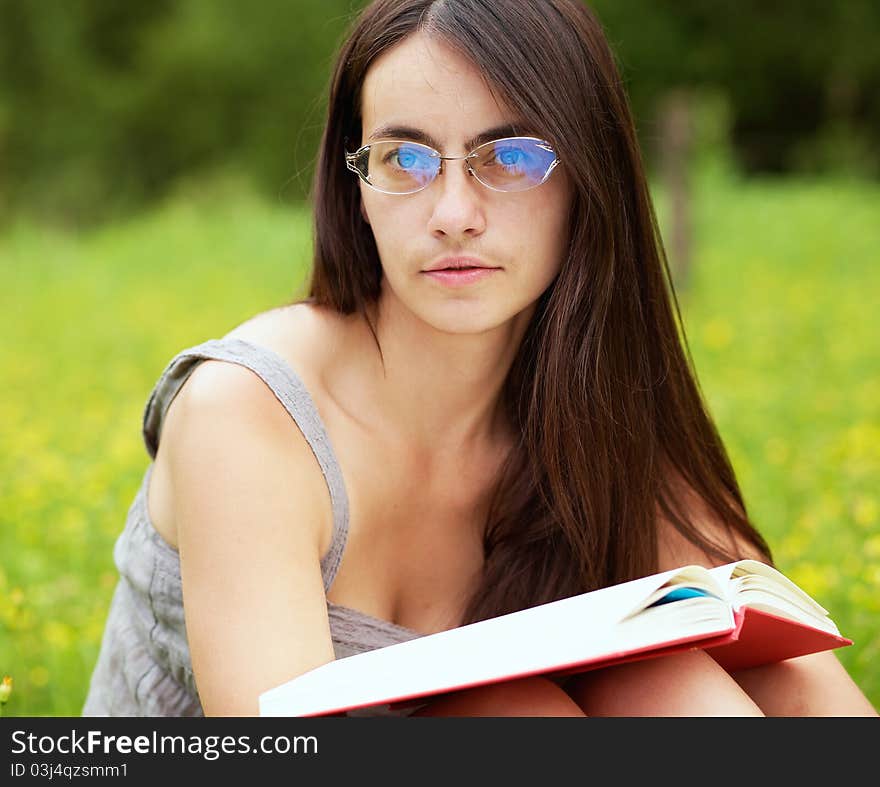 Young female with a book on a green meadow. Young female with a book on a green meadow