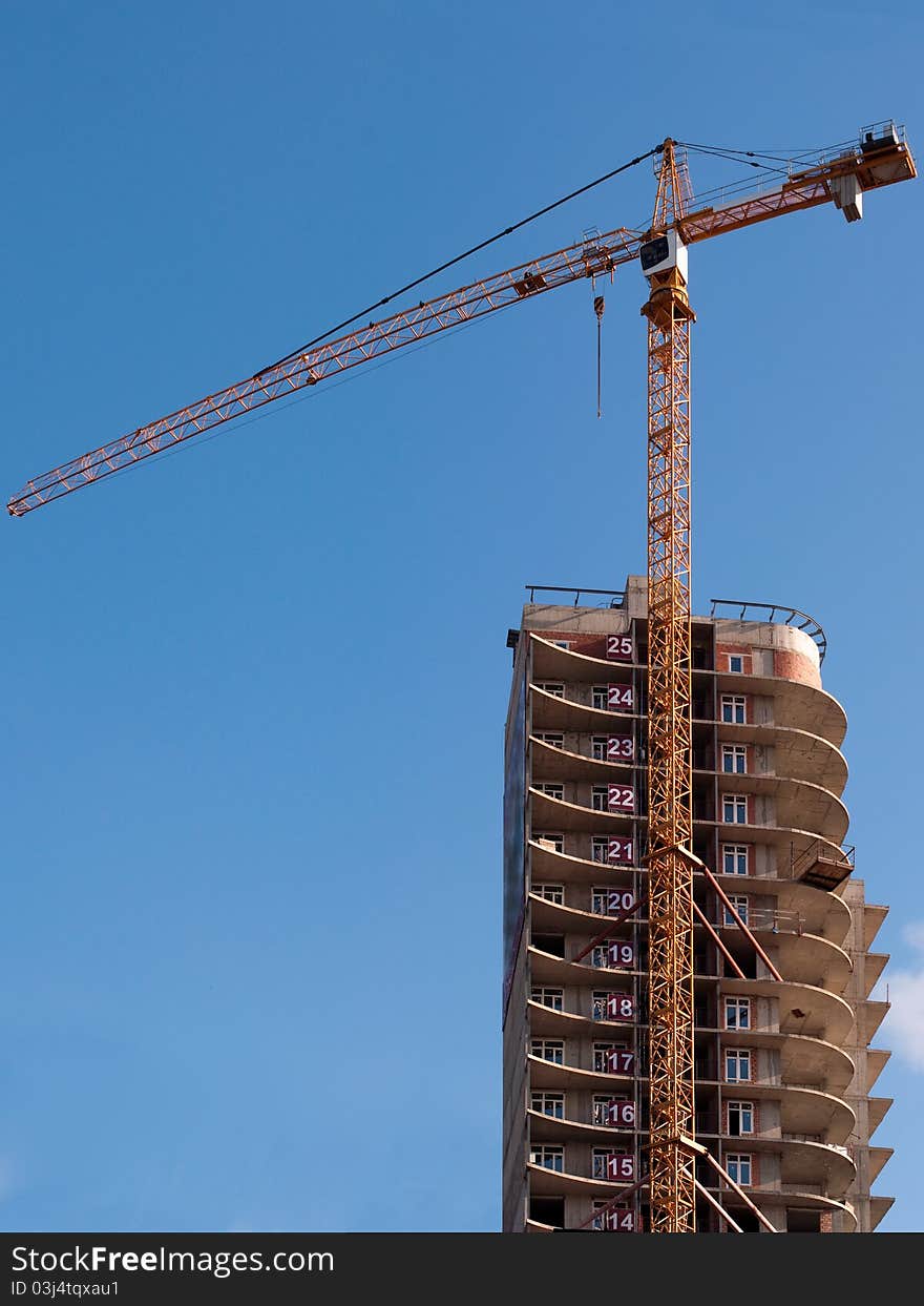 The building crane against the dark blue sky