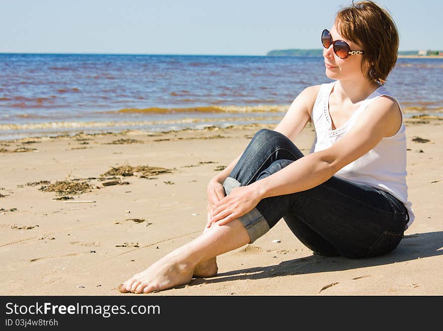 Woman in sunglasses on the beach.