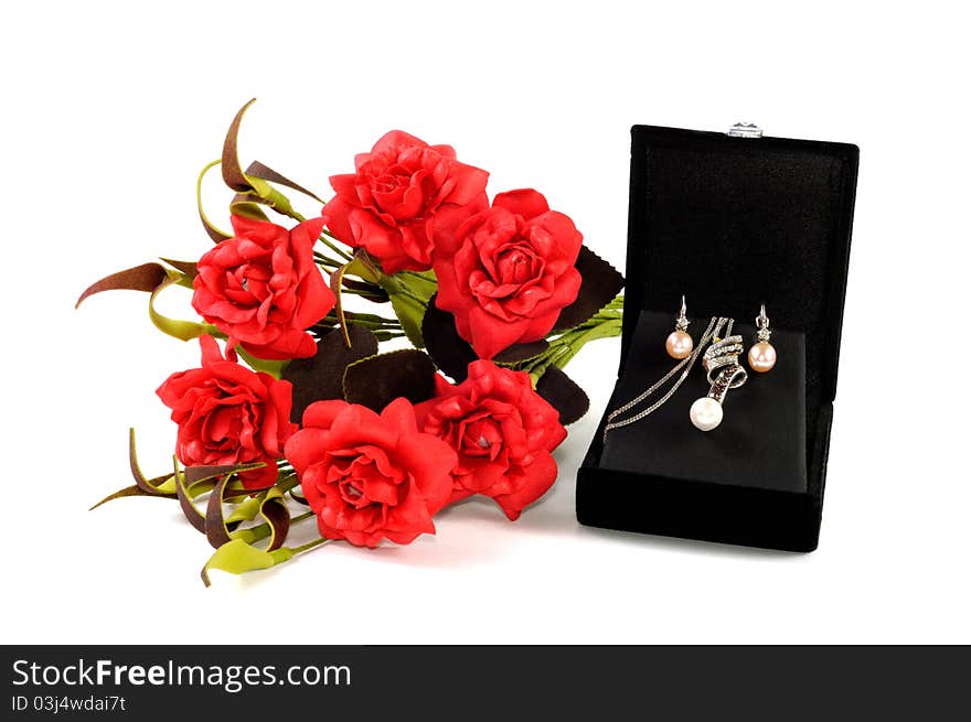 Precious pearls set in open gift box with red flowers