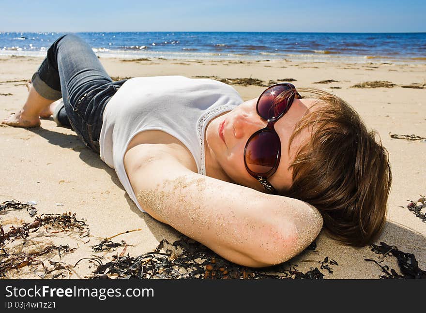 Woman in sunglasses on the beach.